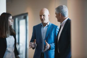 en grupp på tre personer pratar med varandra